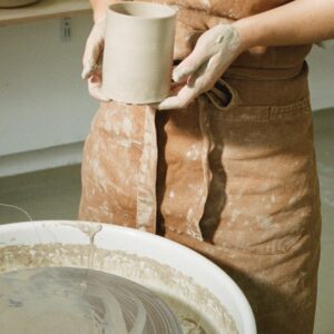 céramiste tournant une tasse de poterie